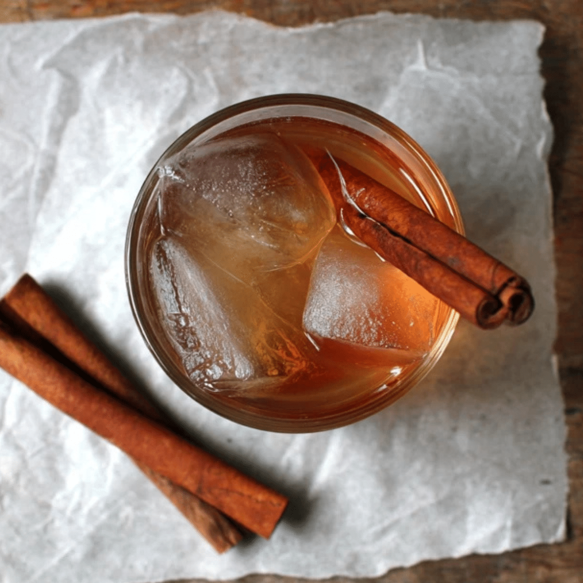 Cinnamon water recipe in a glass with ice cubes and cinnamon sticks
